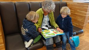grandma reading books to two kids